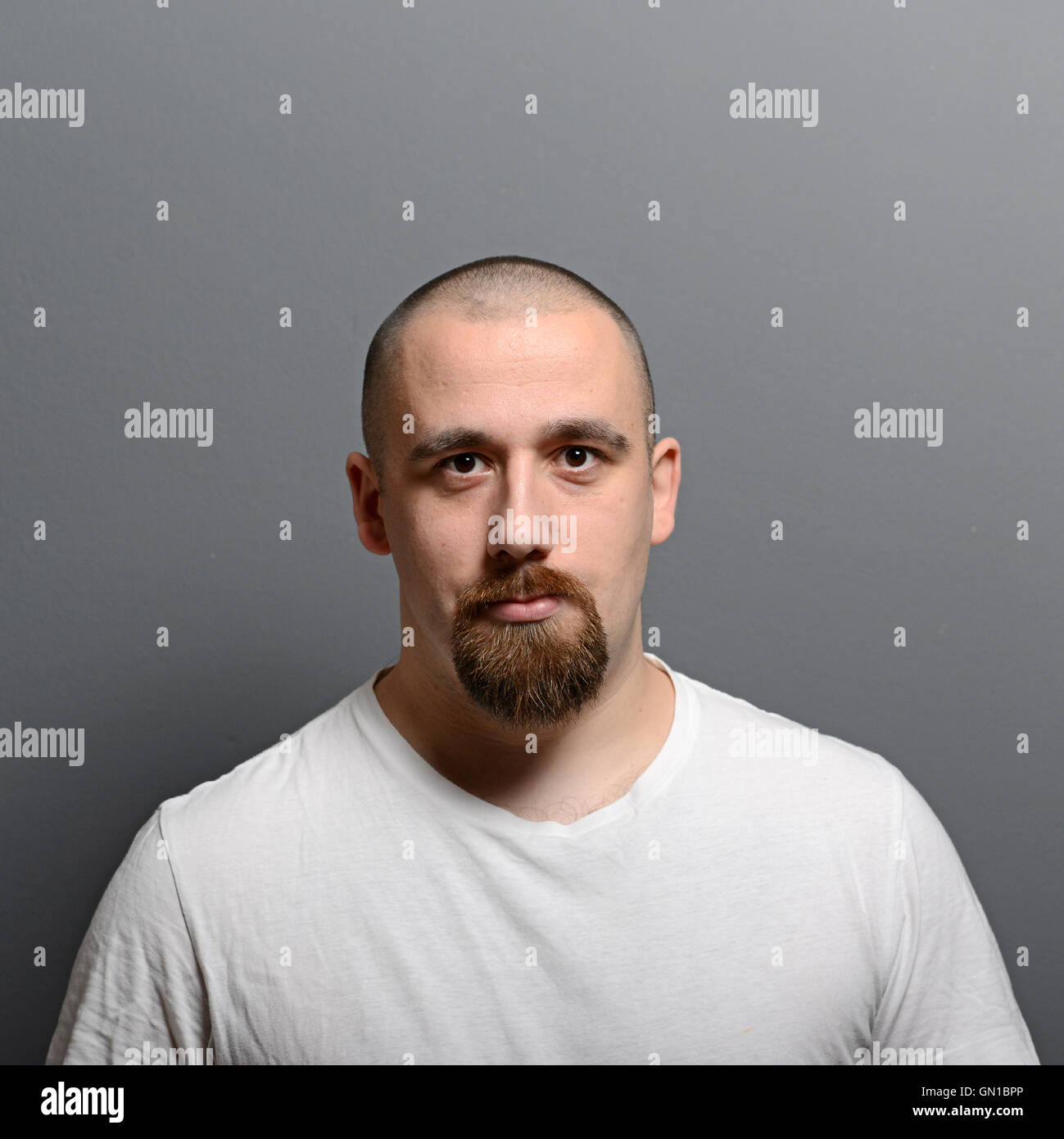 Portrait of a young man standing against gray background Stock Photo ...