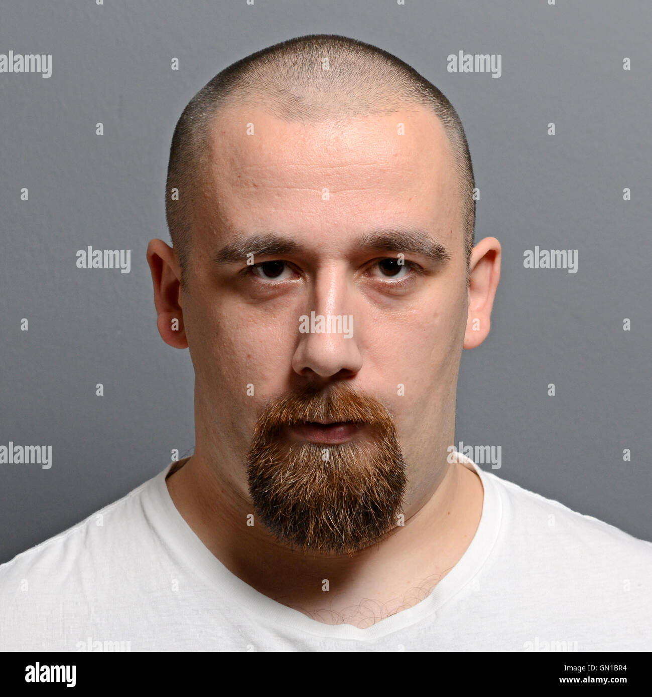 Portrait of a young man standing against gray background Stock Photo ...