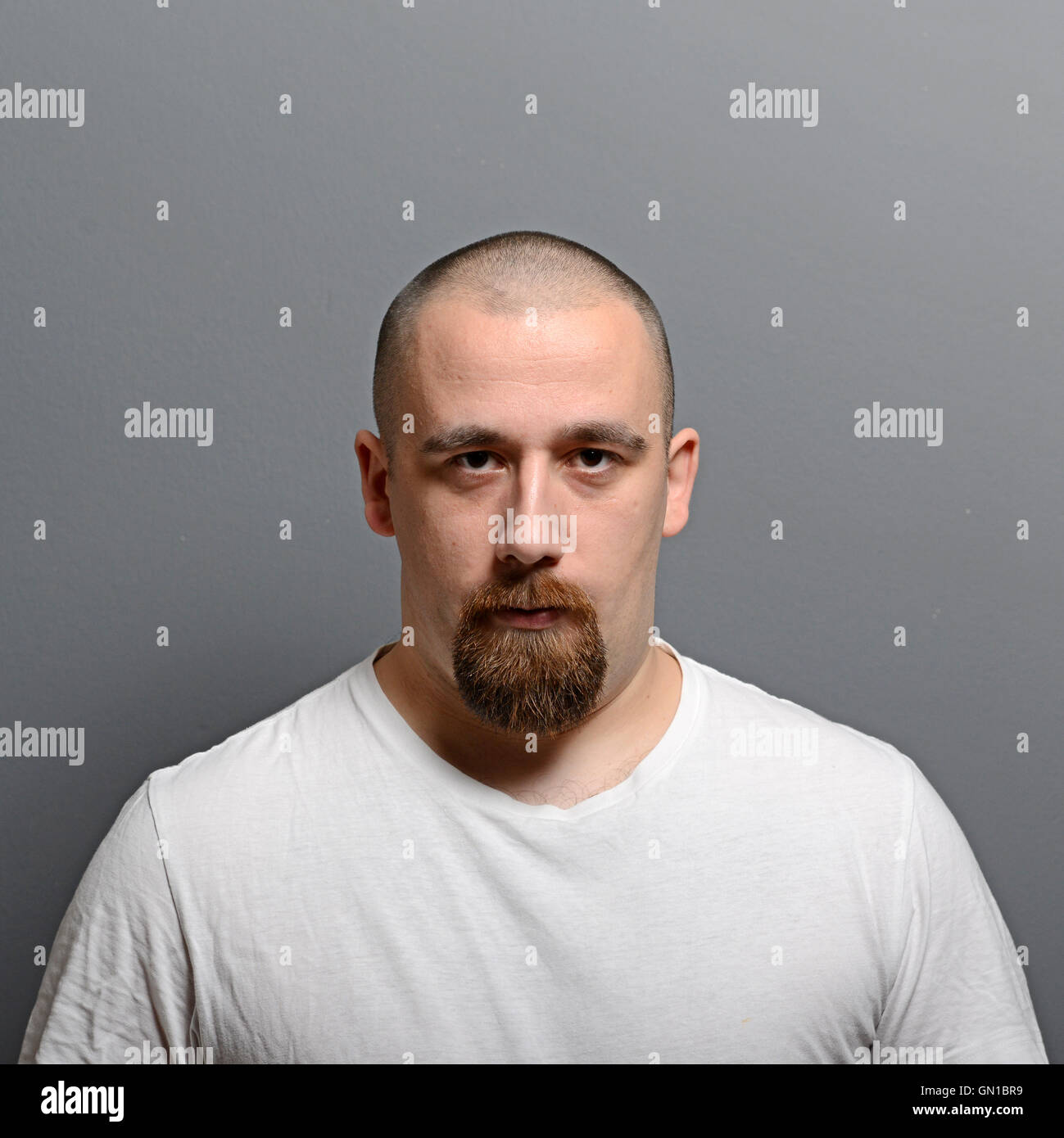 Portrait of a young man standing against gray background Stock Photo ...