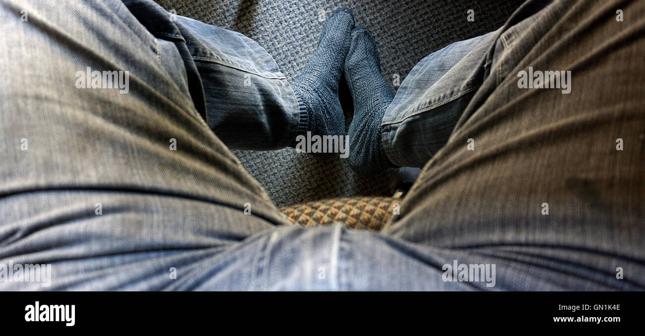 man sitting with no shoes Stock Photo
