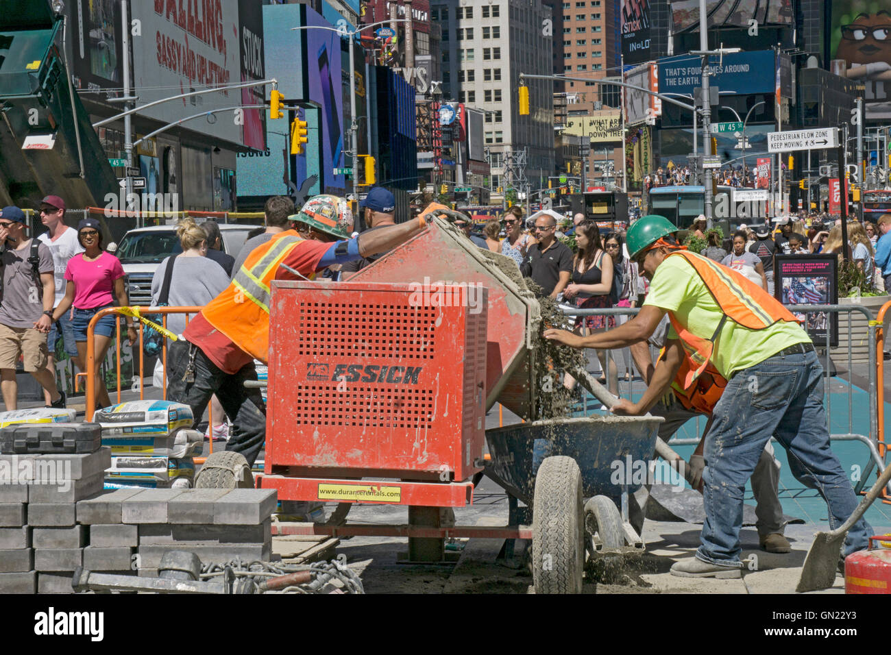Construction workers mixing cement to repave streets in Times Square, Midtown Manhattan, New York City. Stock Photo