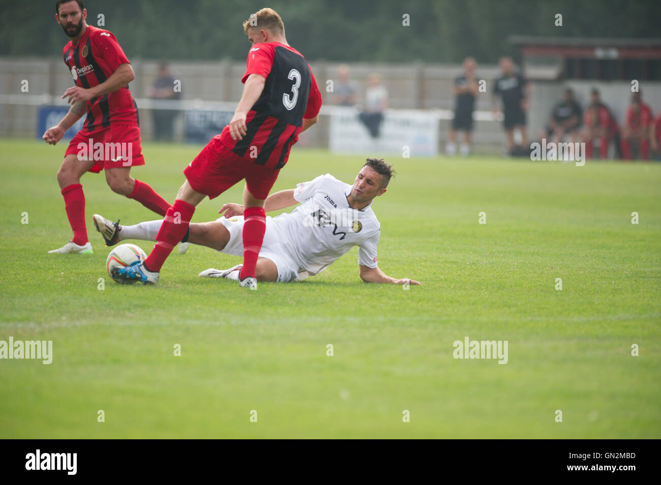 UK. 27th August, 2016. Evo-Stik Division 1 South and West; Winchester FC v Tiverton Town FC. Winchester's King slide tackled Credit:  Flashspix/Alamy Live News Stock Photo