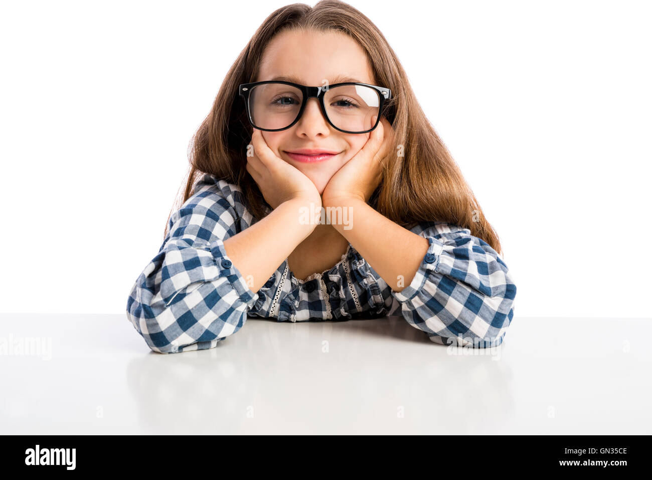 Little girl with glasses sitting on a desk Stock Photo - Alamy