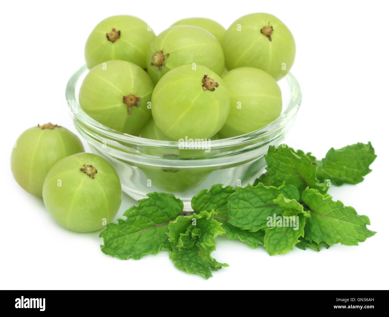 Amla fruits with mint leaves over white background Stock Photo