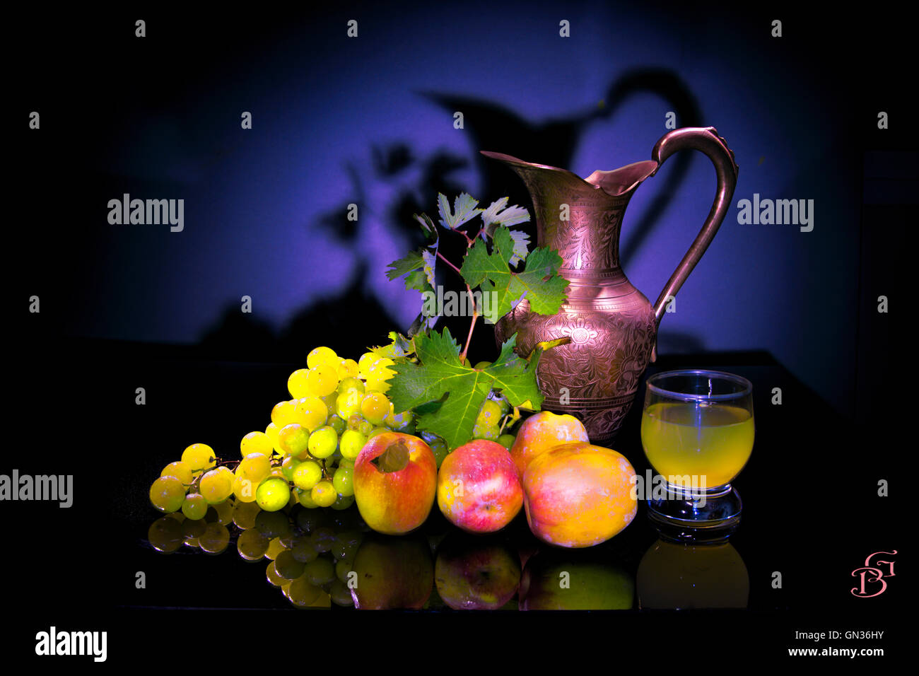 Still life,  a copper jug, grapes and apples in the black table Stock Photo