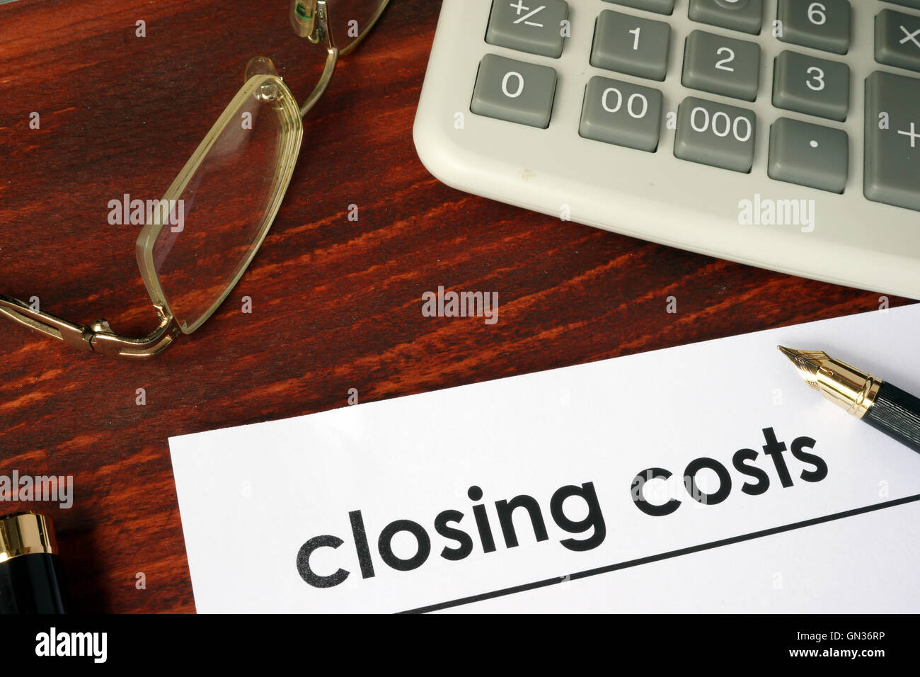 Paper with words closing costs on a wooden background. Stock Photo