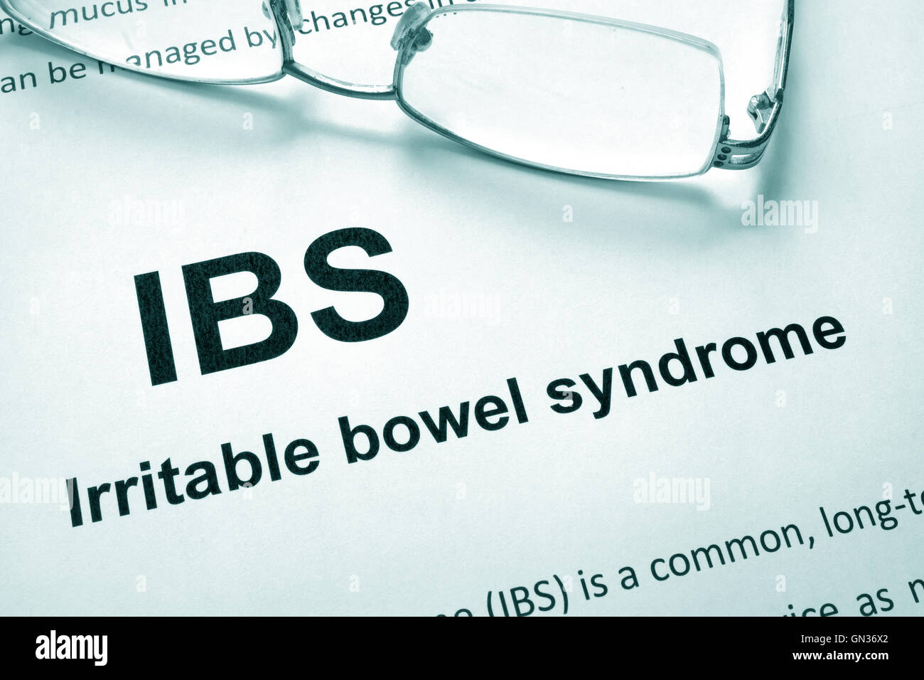 Paper with words Irritable bowel syndrome (IBS) and glasses. Stock Photo