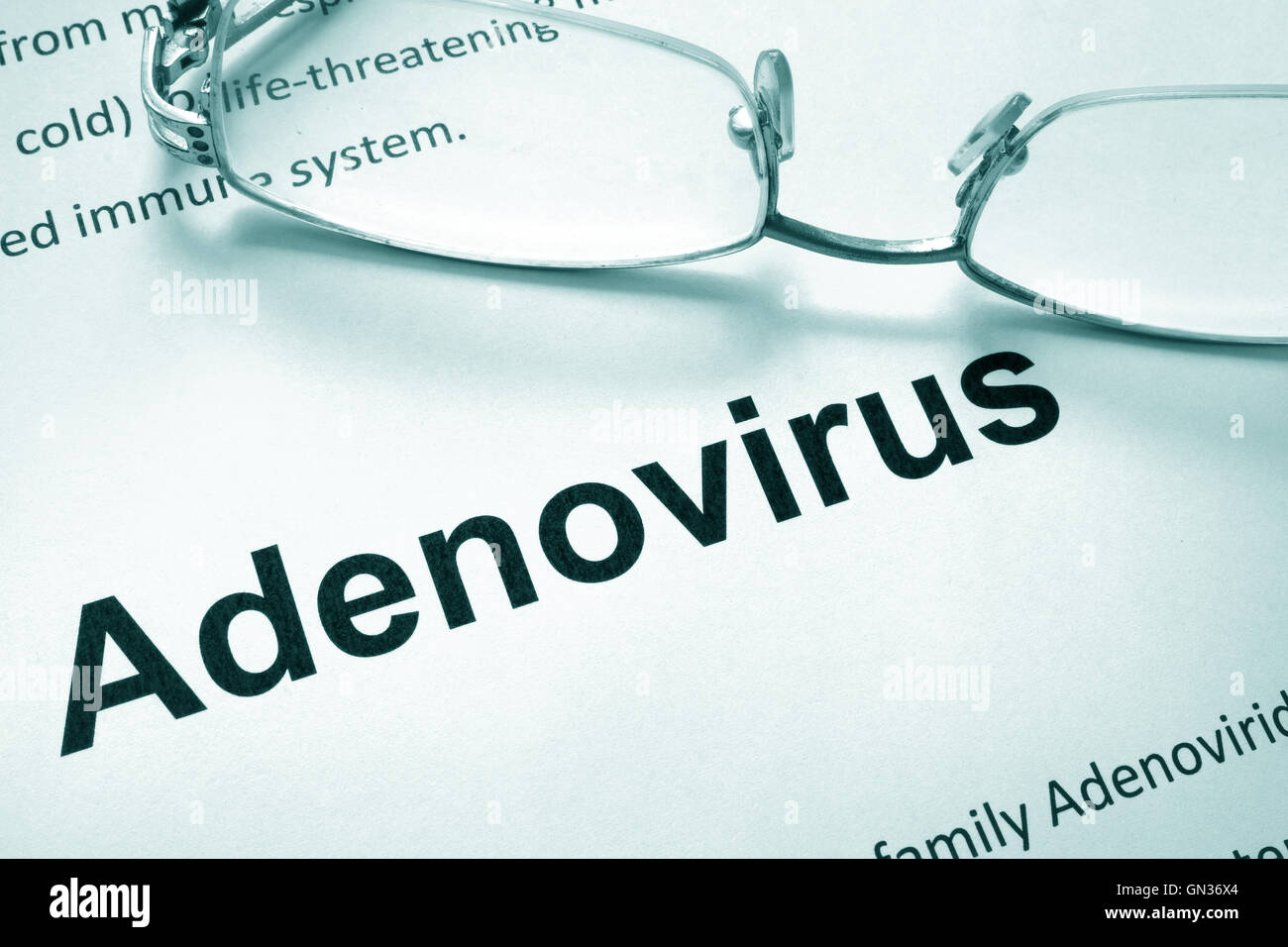 Paper with word adenovirus and glasses. Medical concept. Stock Photo