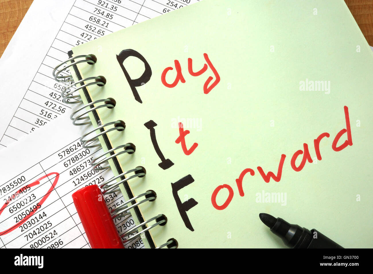 Notebook with  sign Pay It Forward PIF and charts. Stock Photo