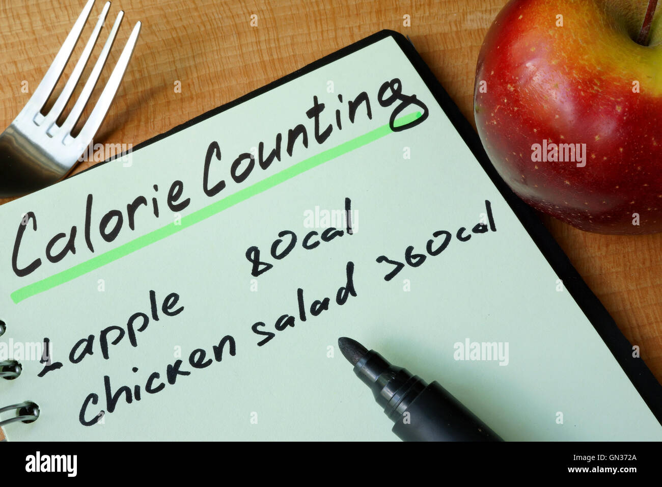 Diary with a record Calorie counting on a table. Stock Photo