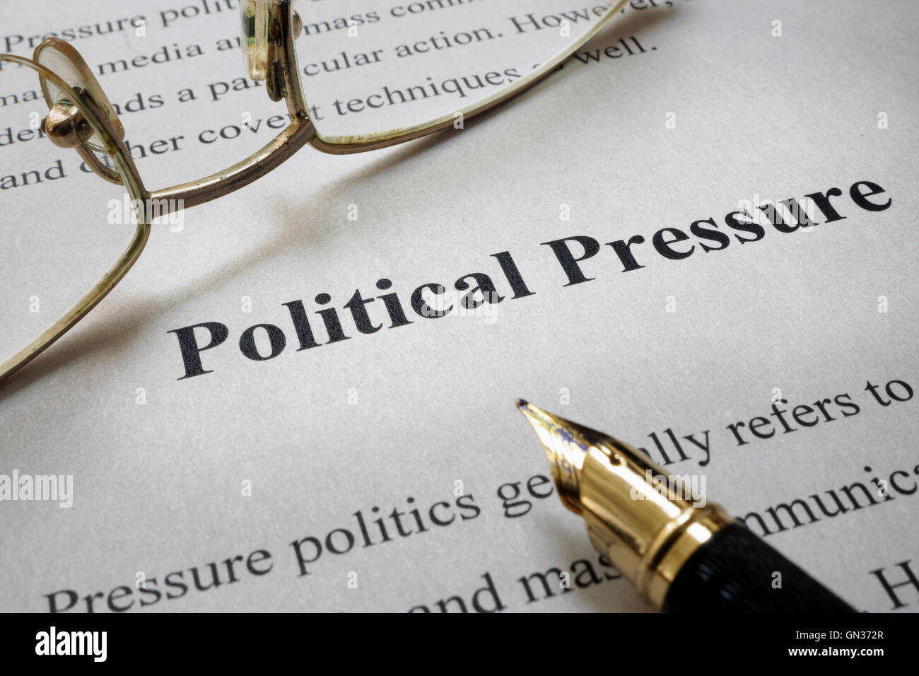 Page of paper with words Political Pressure and glasses. Stock Photo
