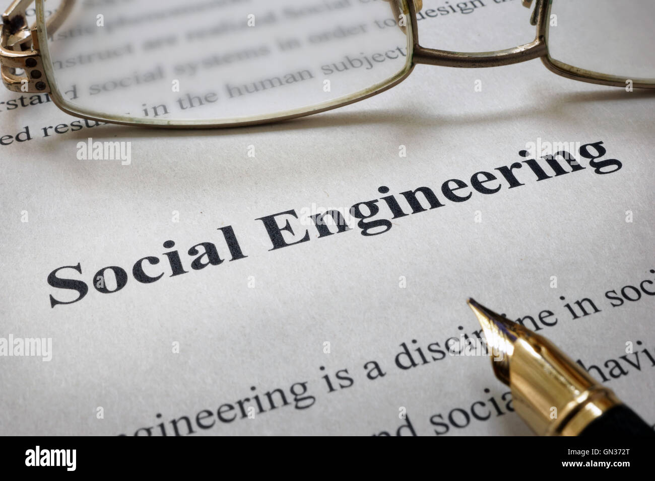 Page of paper with words Social Engineering and glasses. Stock Photo