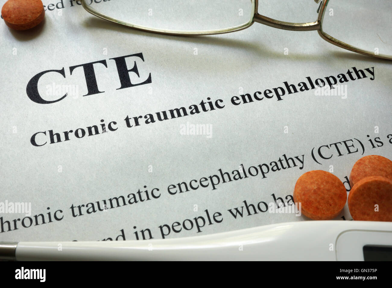 Paper with words CTE Chronic Traumatic Encephalopathy  and glasses. Medical concept. Stock Photo