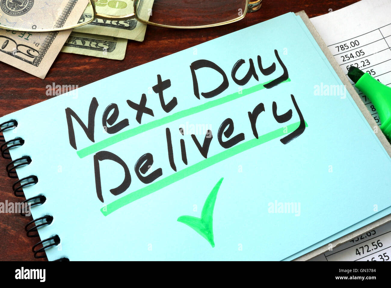 Next day delivery written on a notepad with marker. Stock Photo