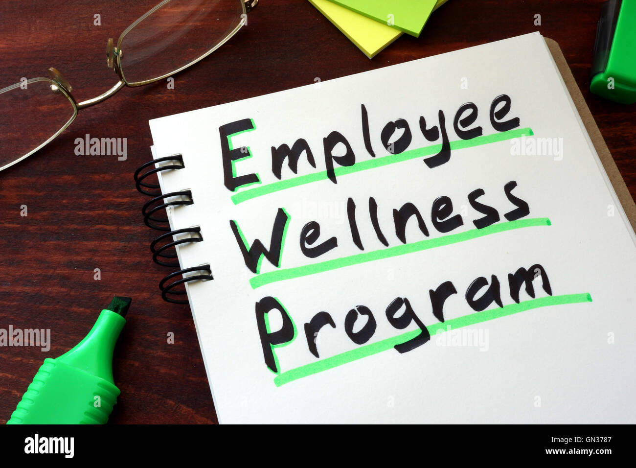 Employee Wellness program written on a notepad with marker. Stock Photo