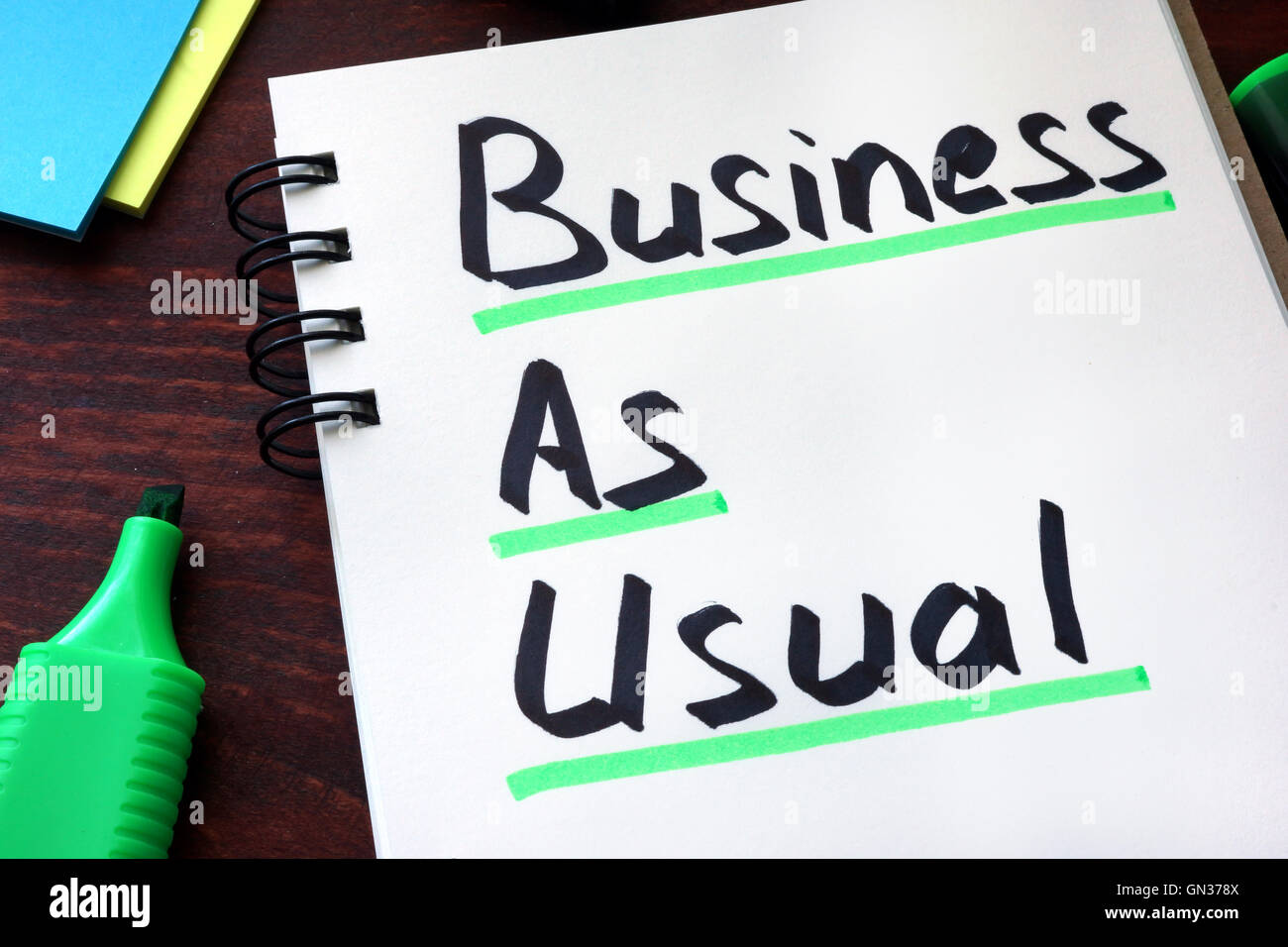 Business As Usual written on a notepad with marker. Stock Photo