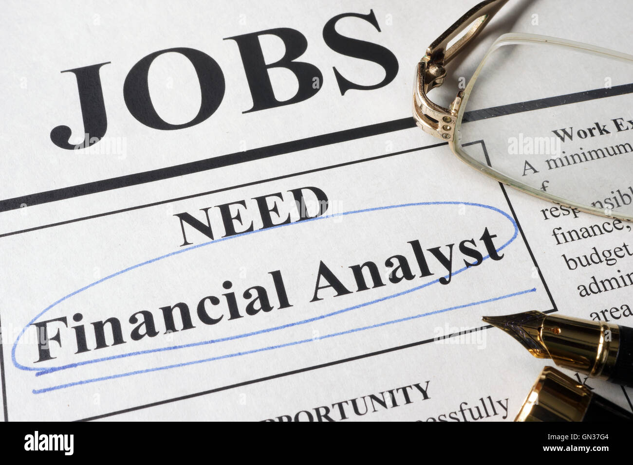 Newspaper with ads for vacancy financial analyst. Employment concept. Stock Photo