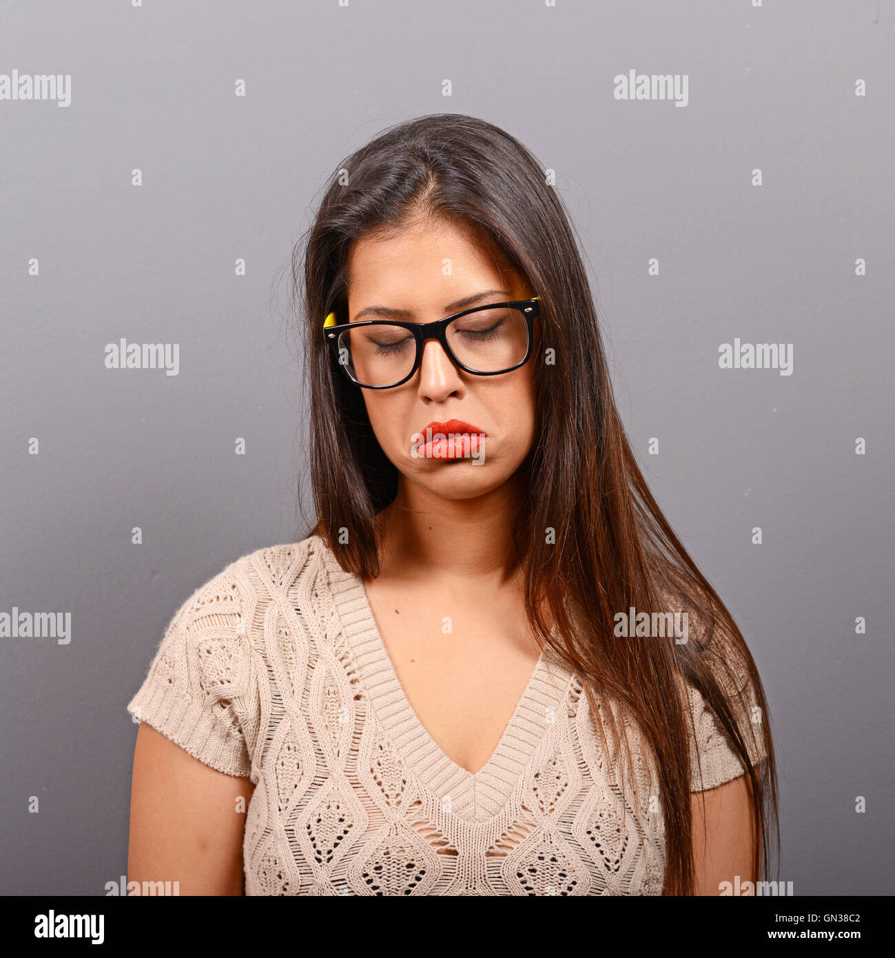 Portrait of a sad woman against gray background Stock Photo - Alamy