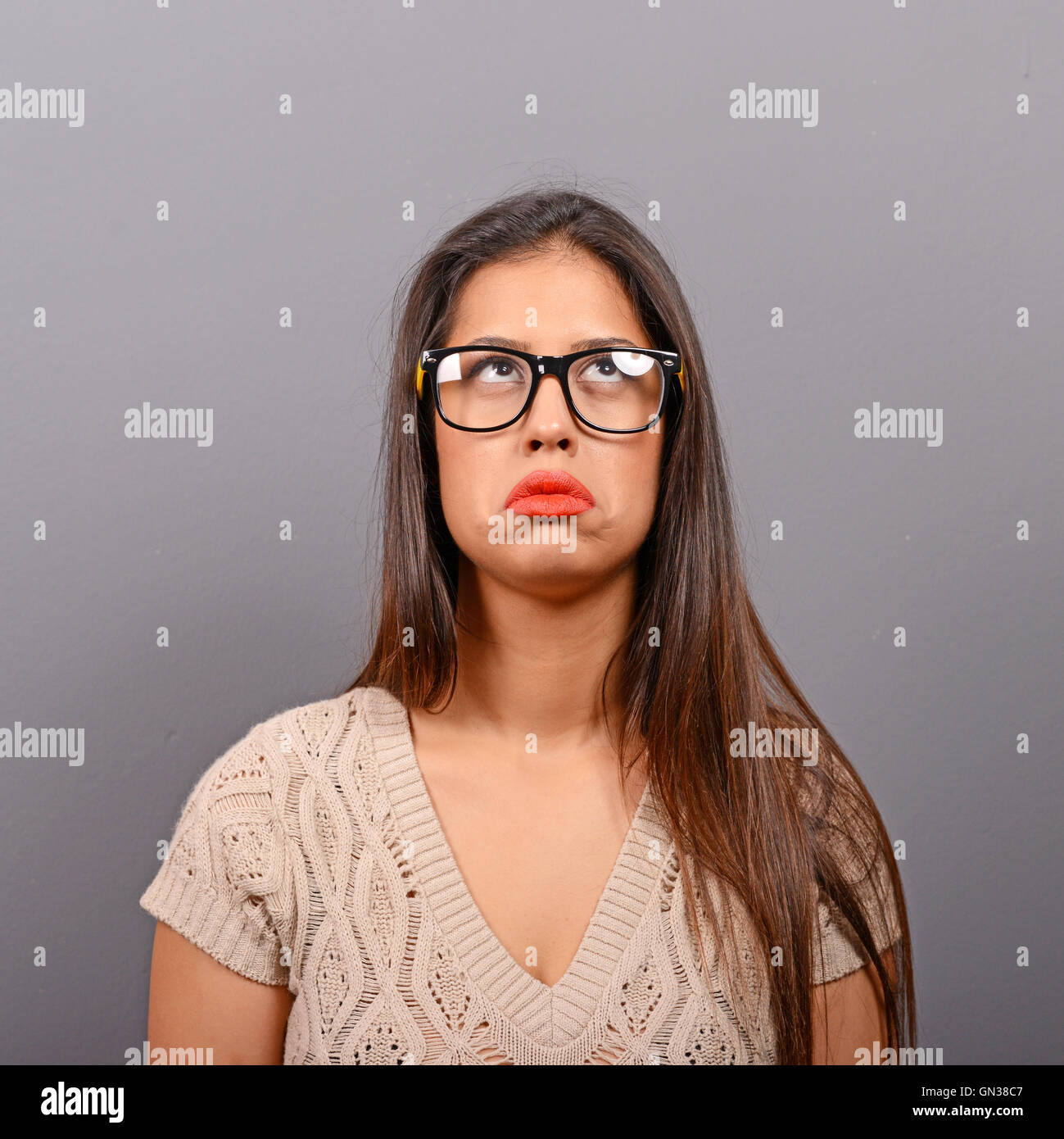 Portrait of a sad woman against gray background Stock Photo - Alamy