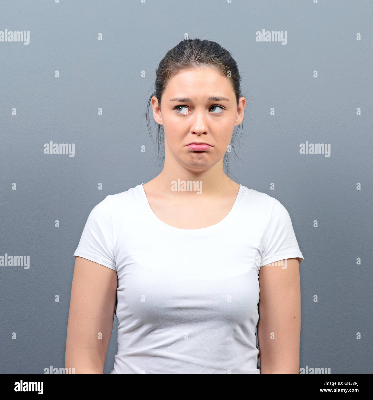 Portrait of a sad woman against gray background Stock Photo - Alamy