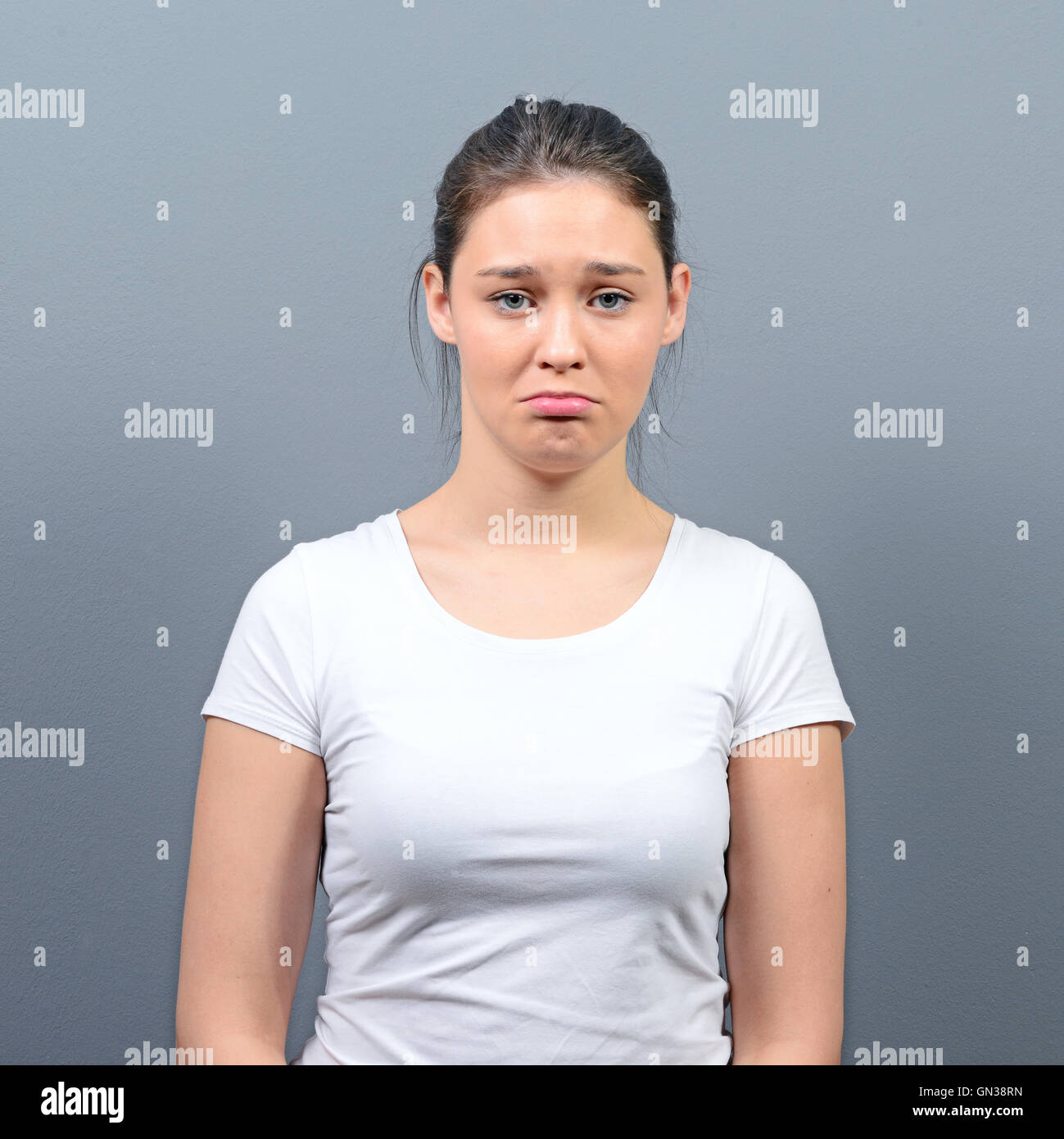 Portrait of a sad woman against gray background Stock Photo - Alamy