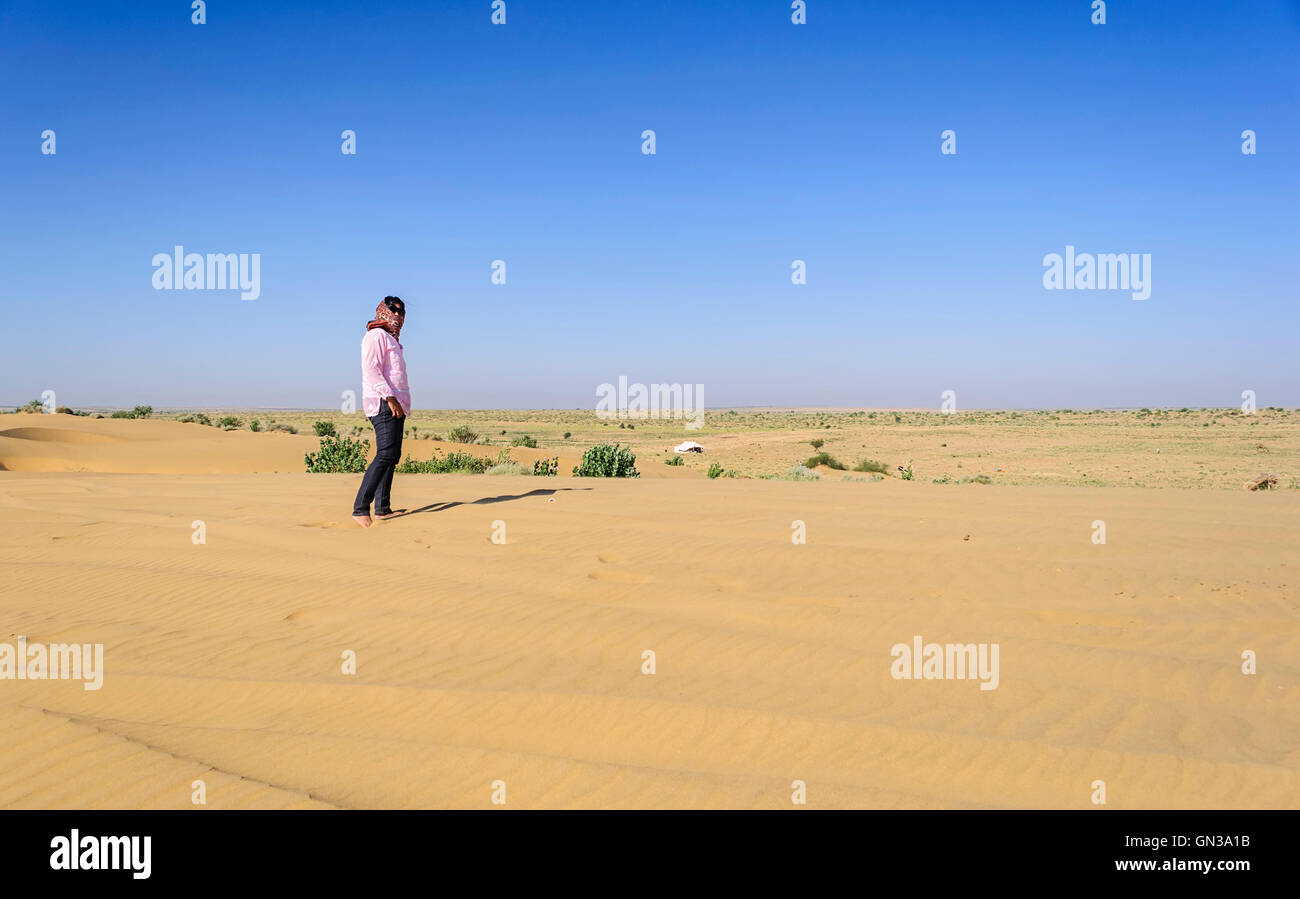 Mature, young Indian lady, lonely tourist standing in barefoot in sand, Desert National Park, Rajasthan, copy Space Stock Photo