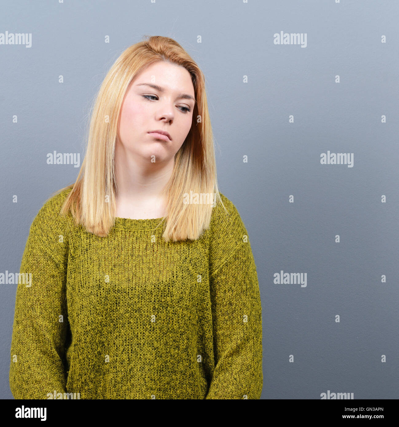Portrait of a sad woman against gray background Stock Photo - Alamy