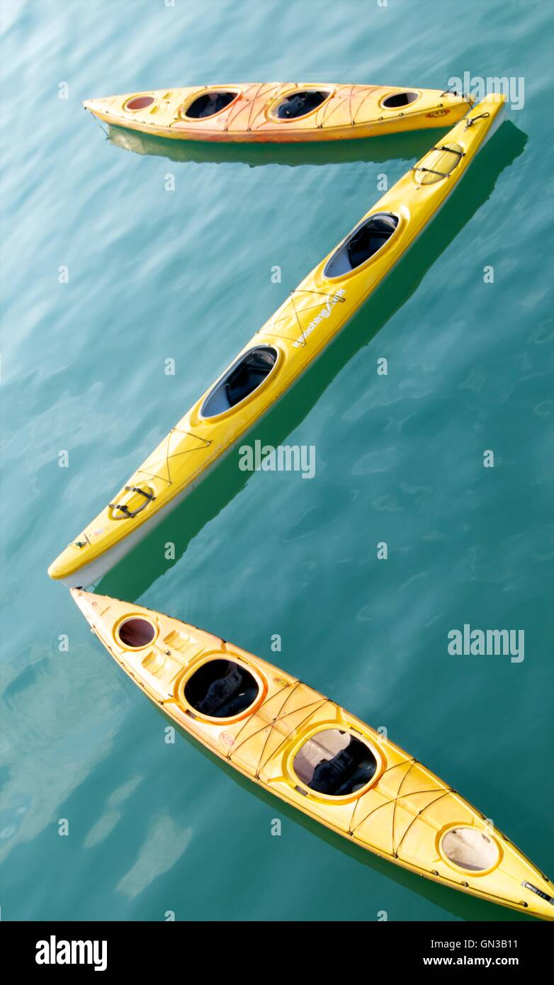 Yellow kayaks and green waters of Ha Long Bay make an interesting contrast in colour and texture Stock Photo