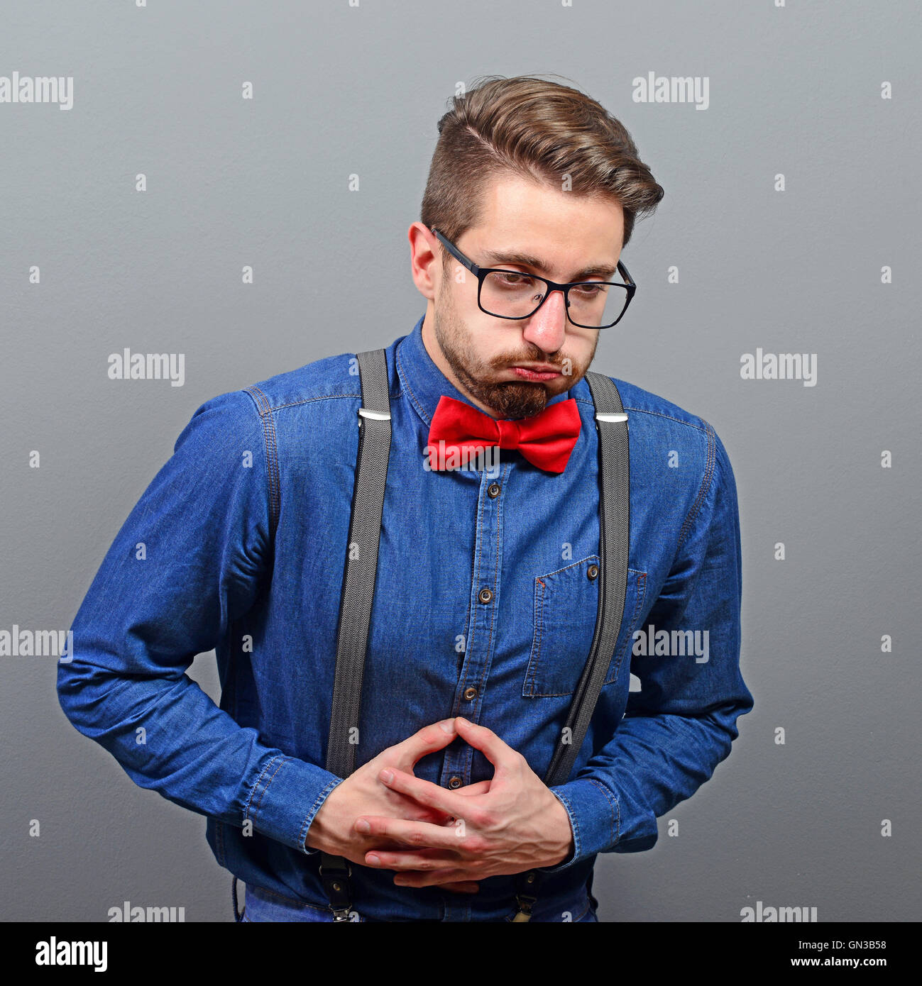 Portrait Of Man With Stomach Pain Against Gray Background Stock Photo