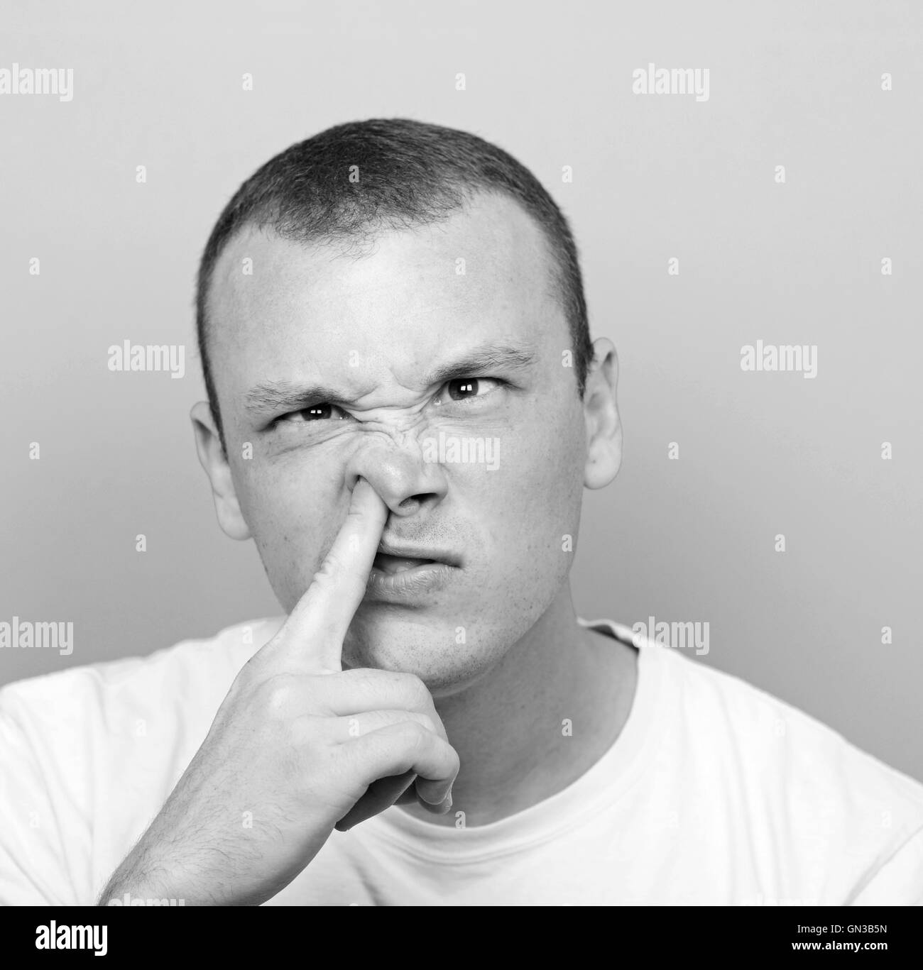 Portrait of a young man with his finger in his nose Stock Photo Alamy