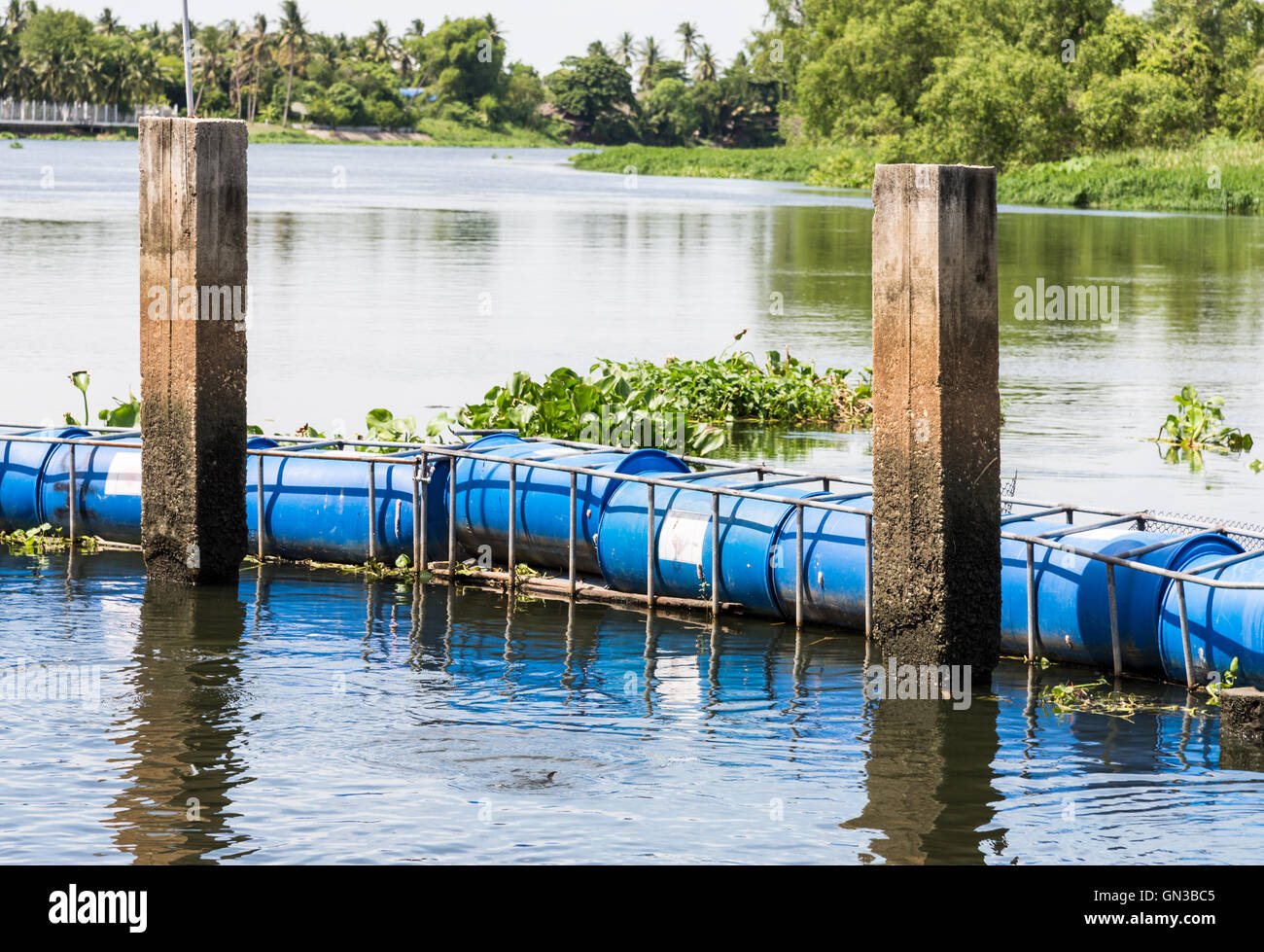 Blue tank buoy is floating near the pier on the large river Stock Photo Alamy