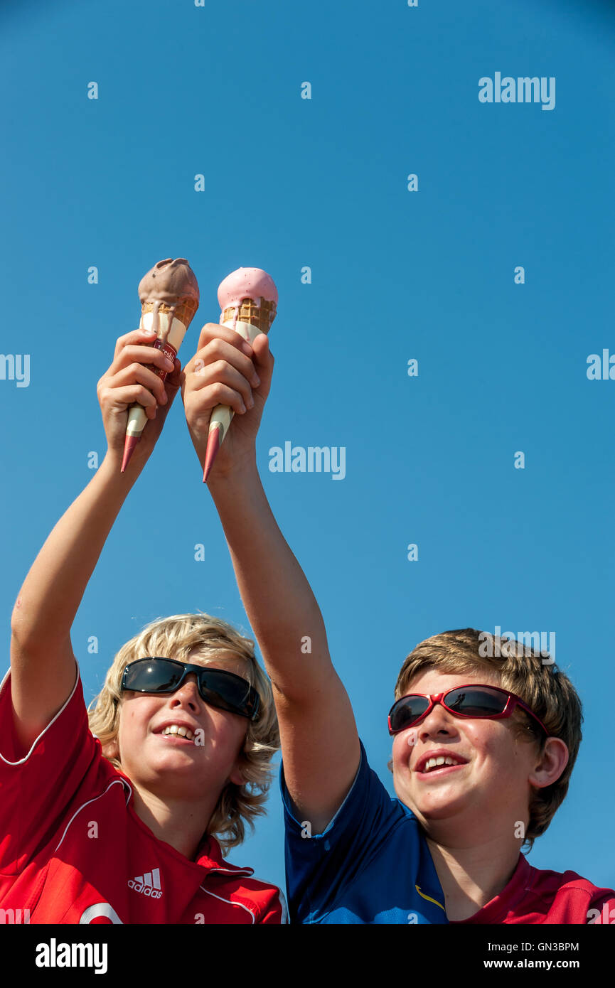 Young boys enjoying a refreshing ice-cream cone. Stock Photo