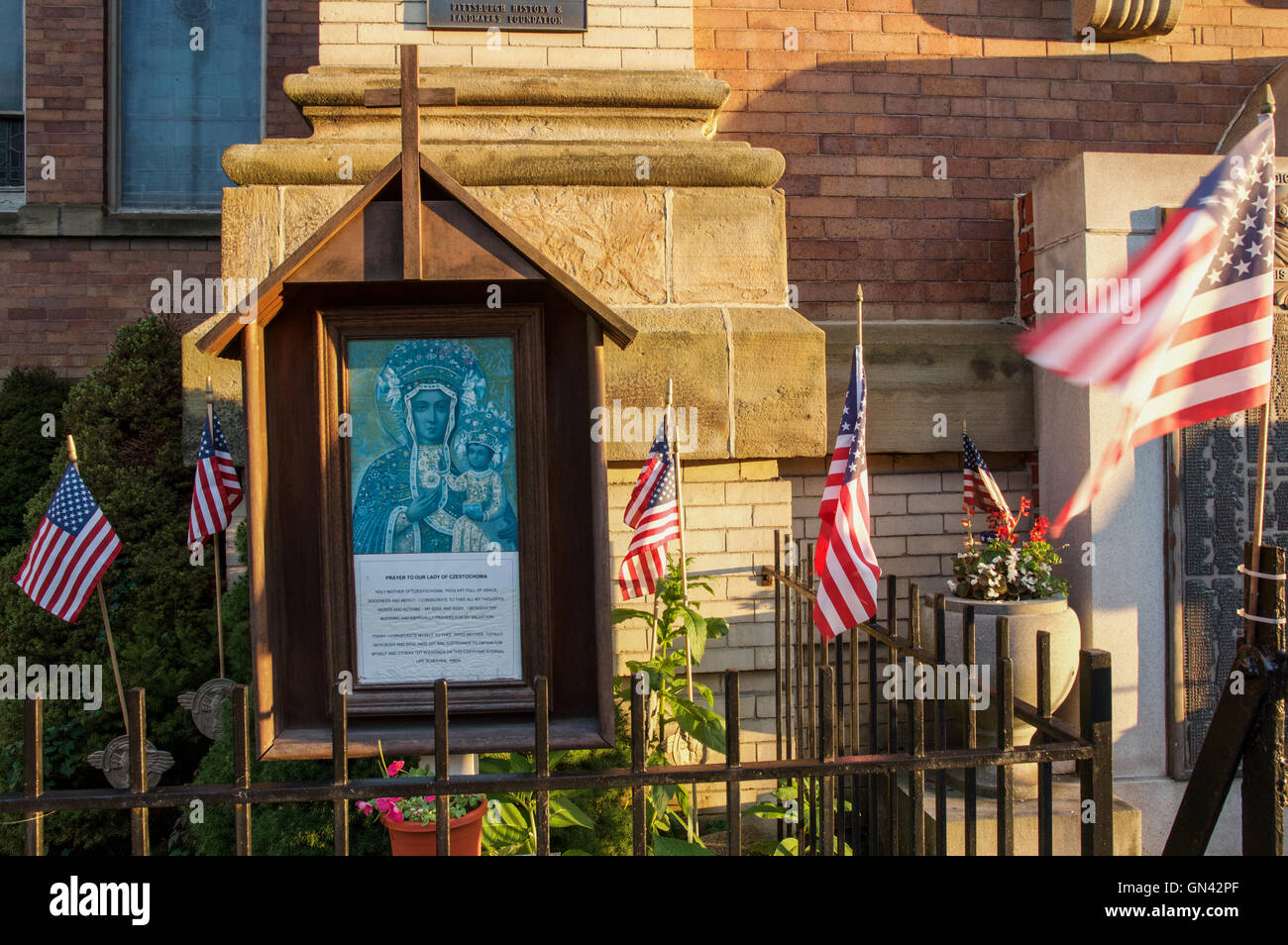 American flags wave next to a shrine to Our Lady of Czestochowa in Pittsburgh's Polish Hill neighborhood Stock Photo