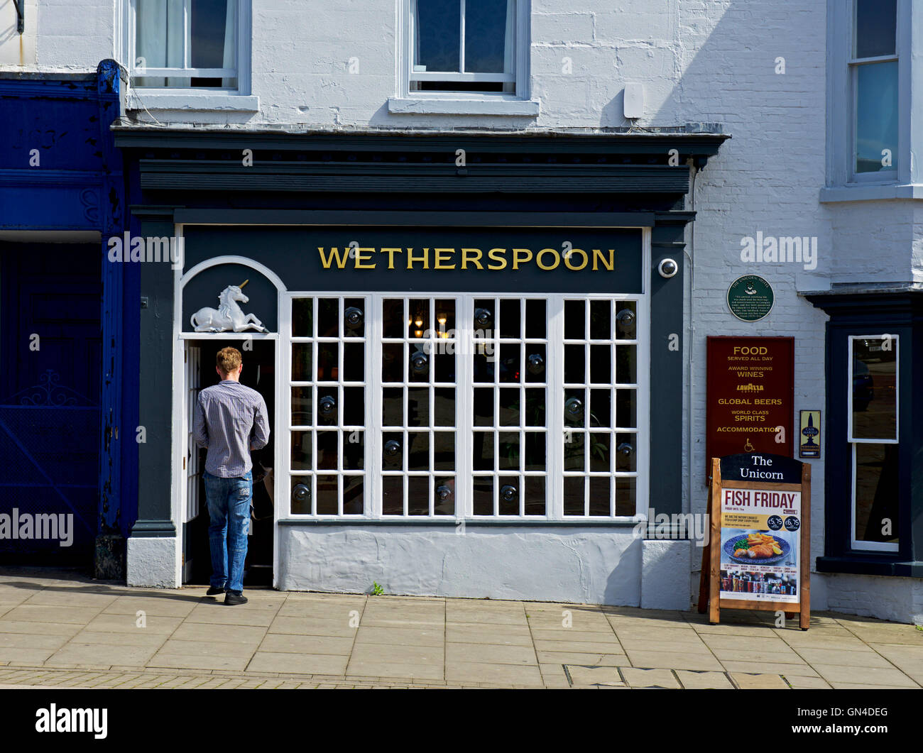 Man walking into the Unicorn hotel, a Wetherspoon pub in Ripon, North Yorkshire, England UK Stock Photo