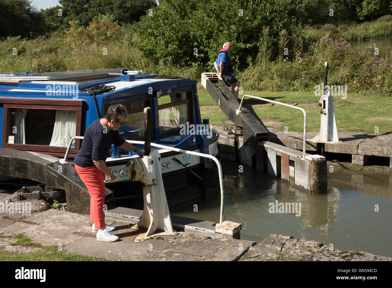 Holidaymakers opening a lock on the Kennet and Avon canal near Devizes Wiltshire England UK Stock Photo