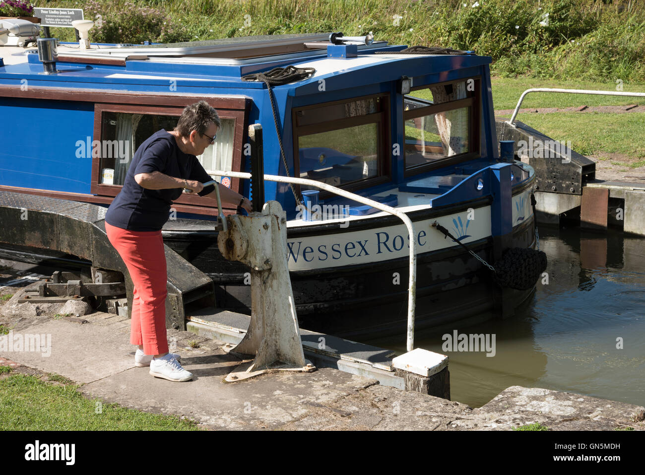 Holidaymakers opening a lock on the Kennet and Avon canal near Devizes Wiltshire England UK Stock Photo
