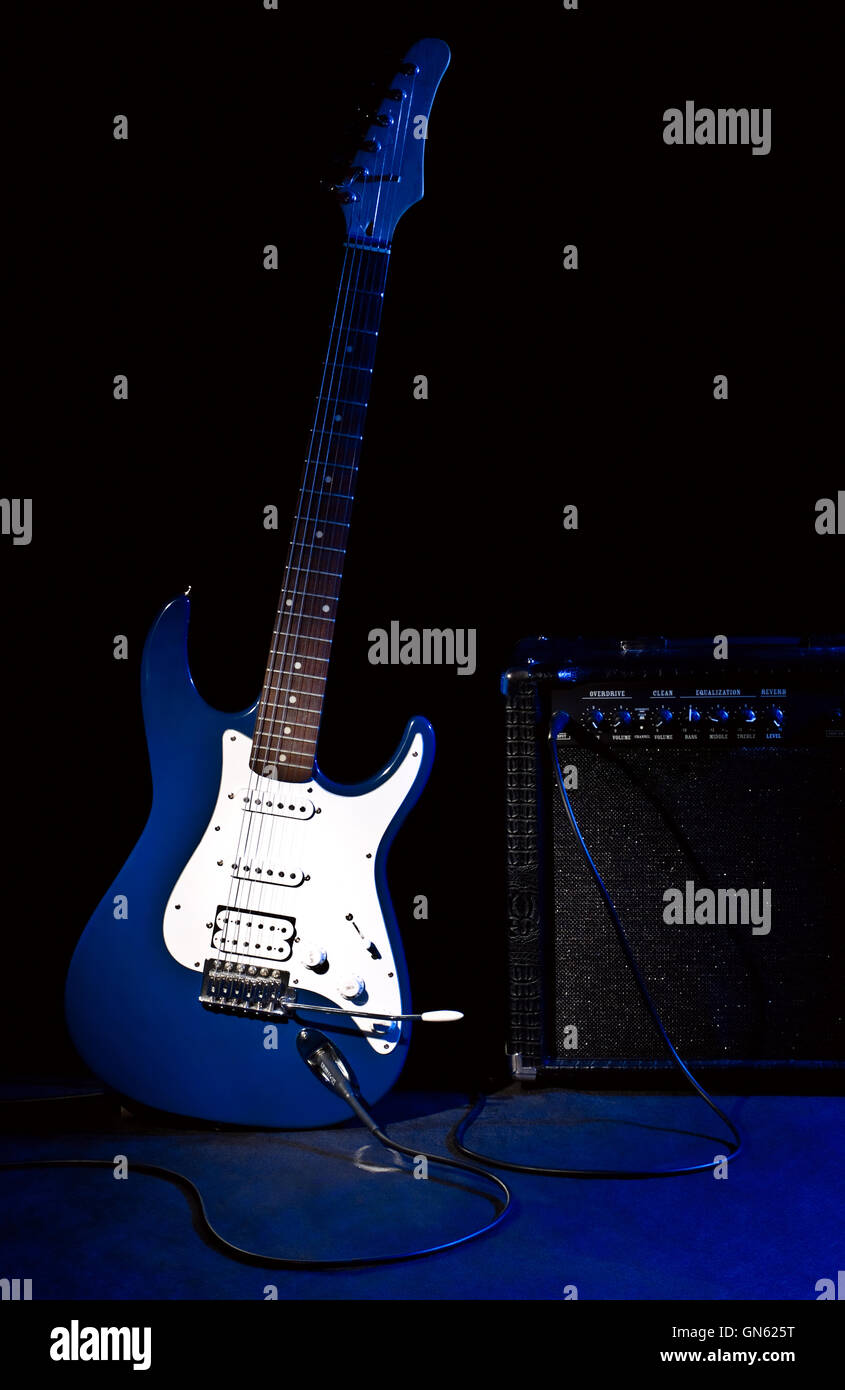 electric guitar and combo amplifier in rays of blue light Stock Photo