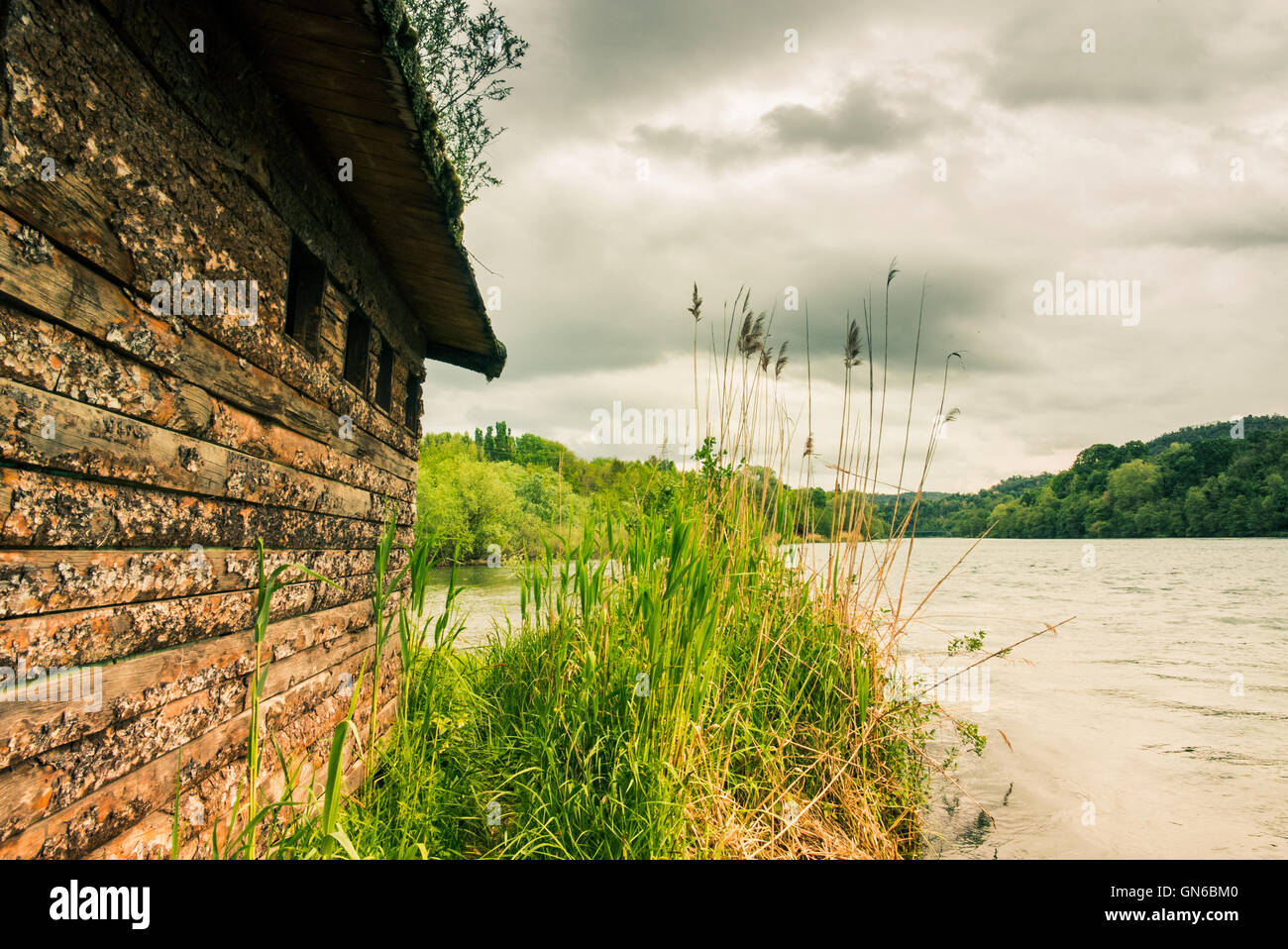 Wooden house by the river in a cloudy day Stock Photo - Alamy