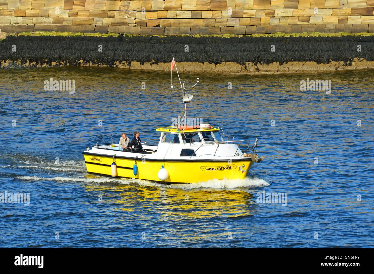 Yellow boat entering Whitby harbour North Yorkshire England UK Stock ...