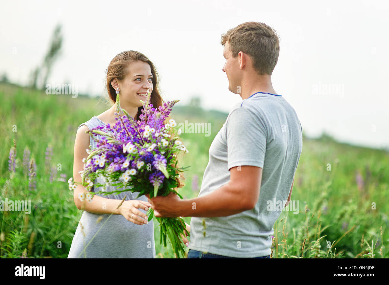 young couple in love walking on the summer meadow Stock Photo