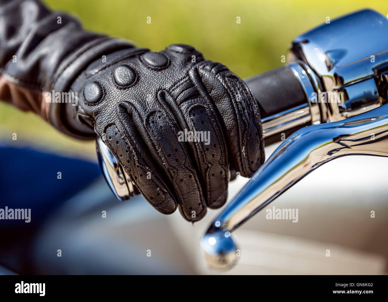 Human hand in a Motorcycle Racing Gloves holds a motorcycle throttle control. Hand protection from falls and accidents. Stock Photo