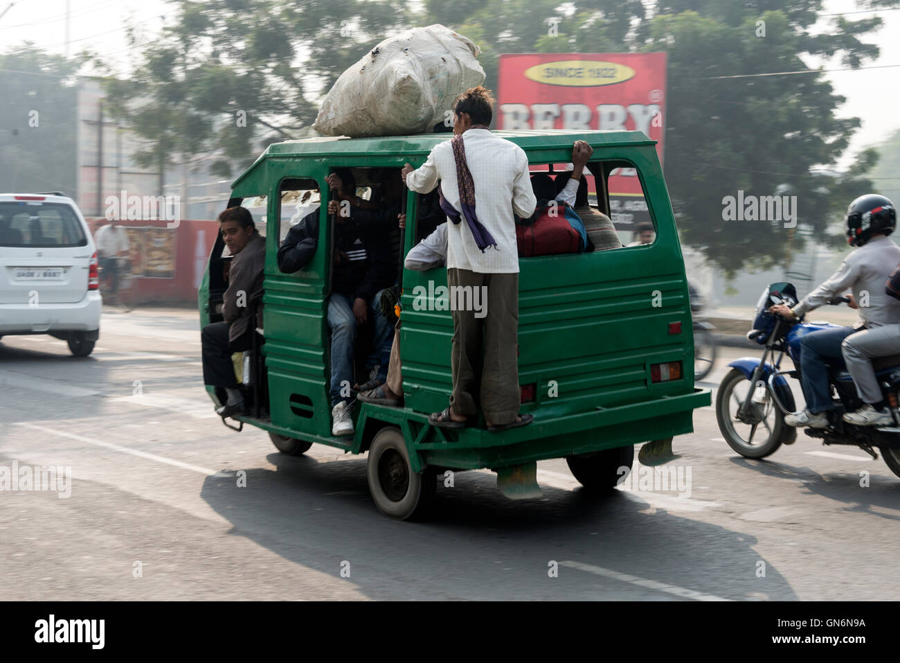 An overloaded tut-tut on a busy main road in Agra, Uttar Pradesh, India Stock Photo
