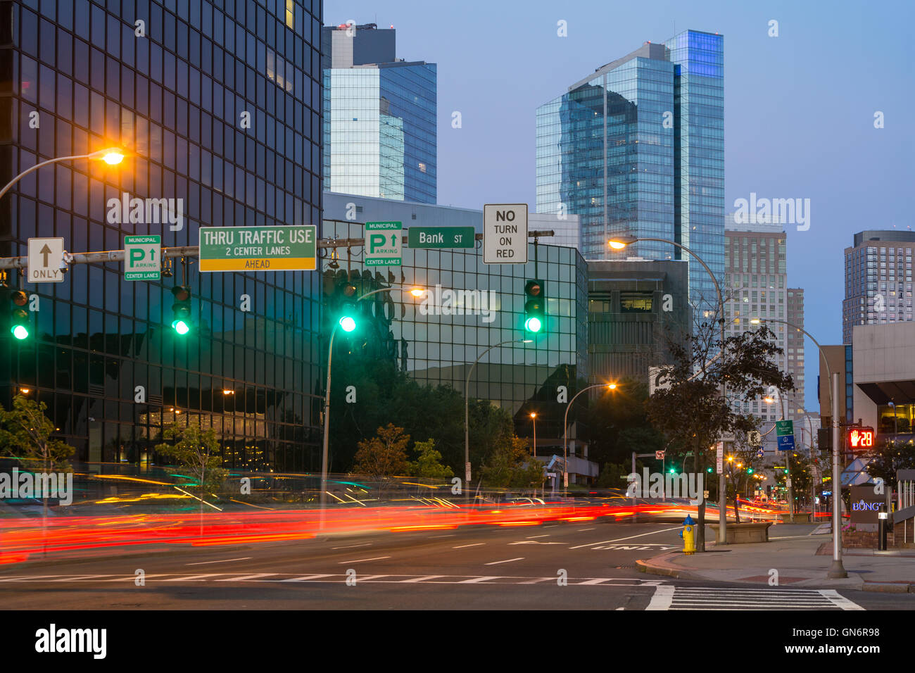 Traffic creates light trails at twilight entering the downtown area of White Plains, New York. Stock Photo