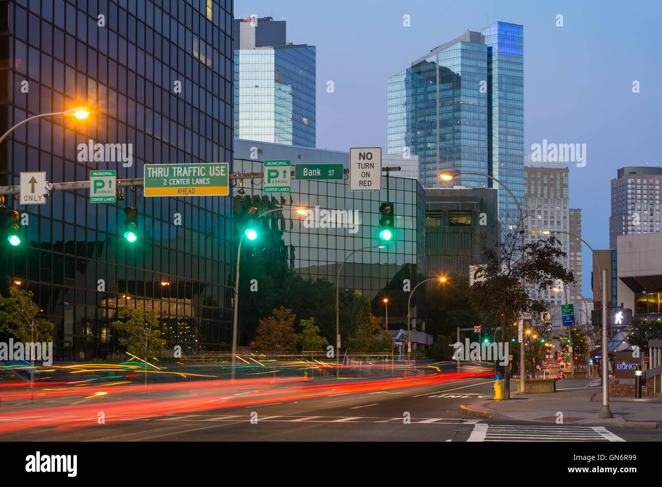Traffic creates light trails at twilight entering the downtown area of White Plains, New York. Stock Photo