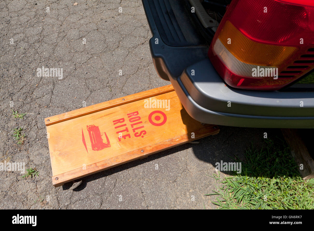 Wooden mechanic's roller creeper under car - USA Stock Photo