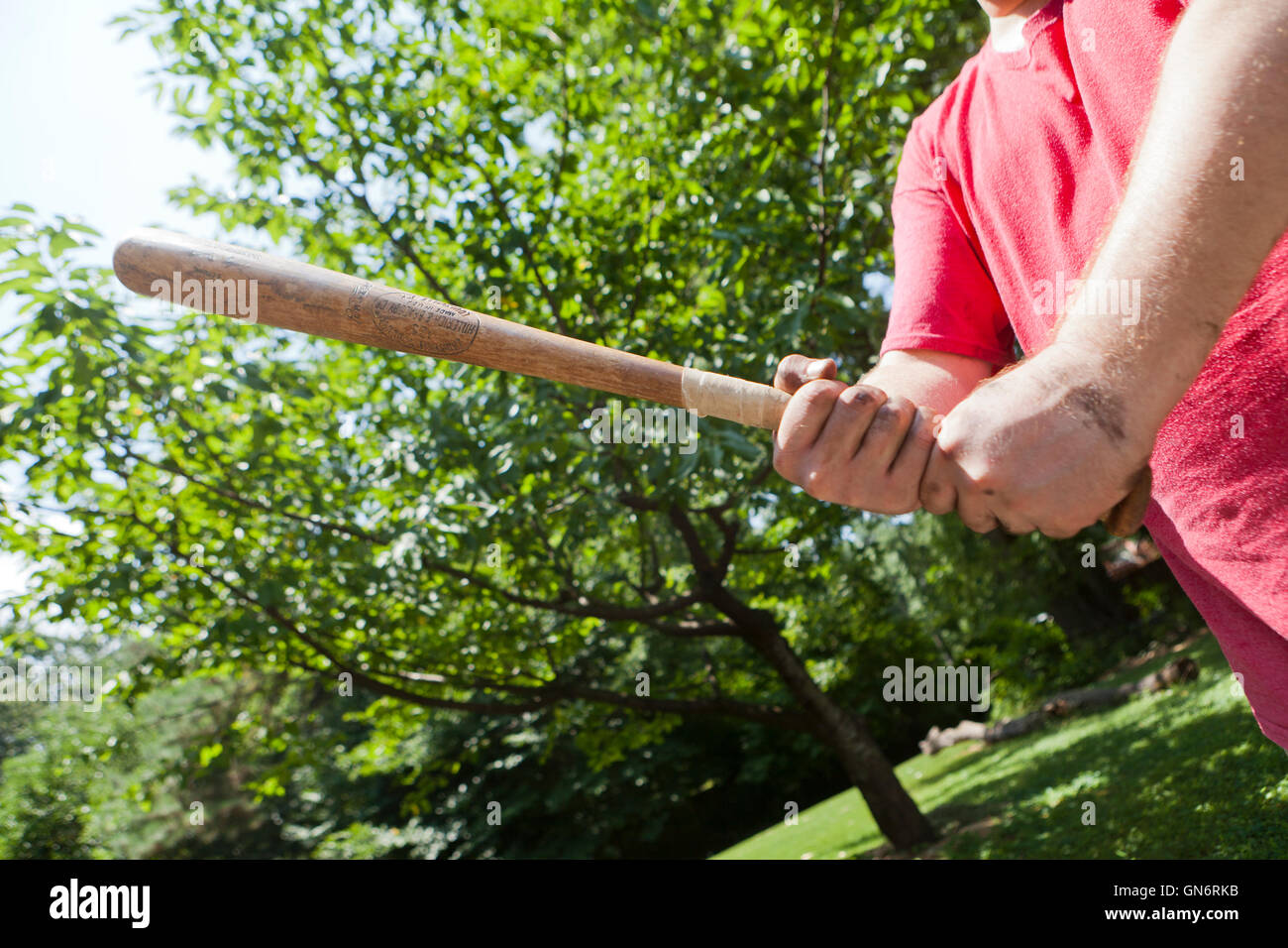 Man holding a wooden baseball bat preparing to swing in self defense