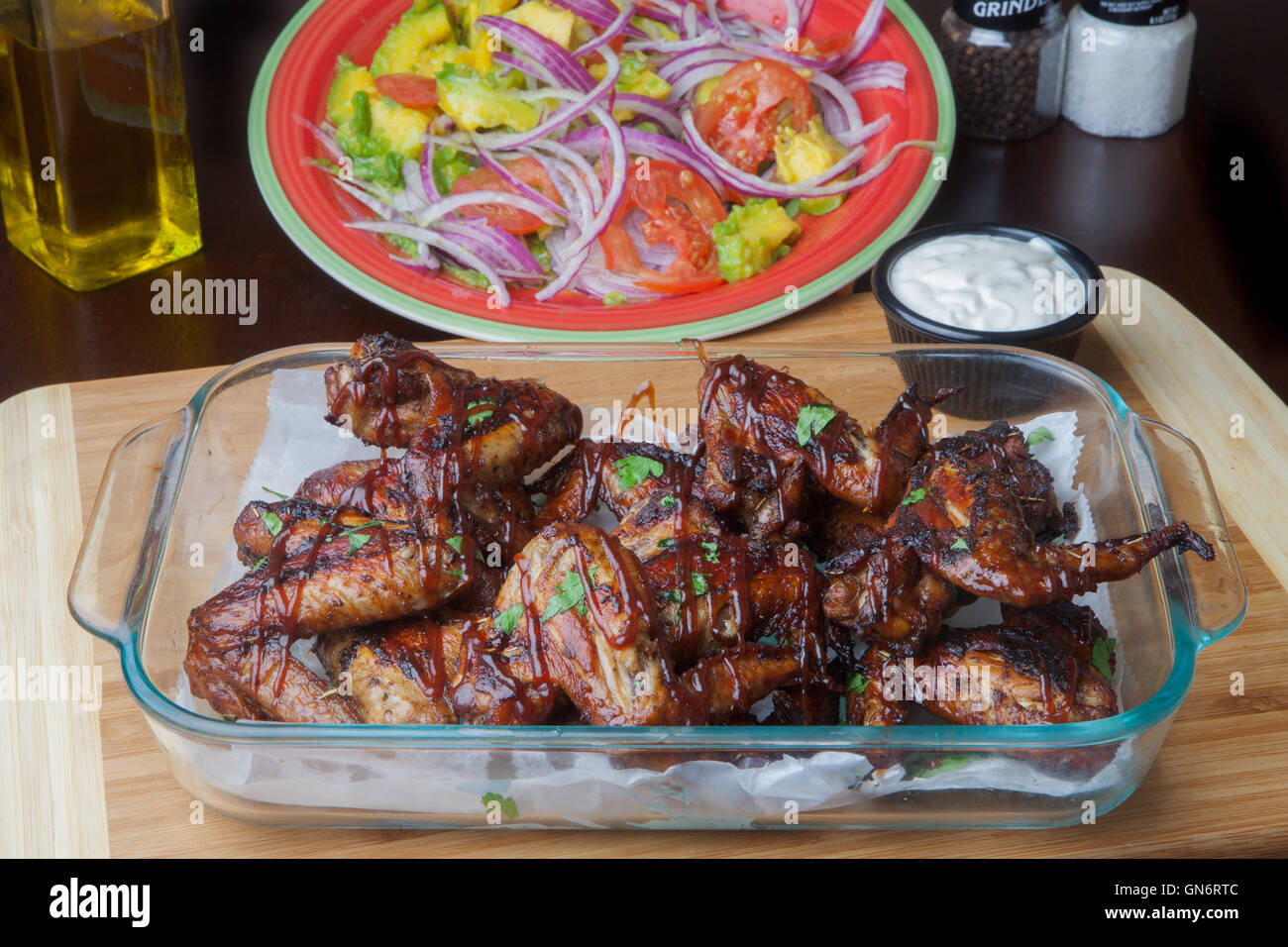 Chicken Wings Avocado red onion tomato salad blue cheese olive oil slat and pepper grinder Stock Photo