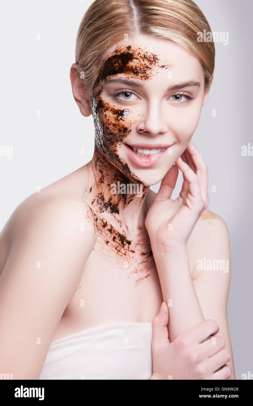 Beautiful Young Woman Facial treatment skin cleansing and peeling. exfoliation of old skin cells, rejuvenation. Natural  coffee peeling skin Stock Photo