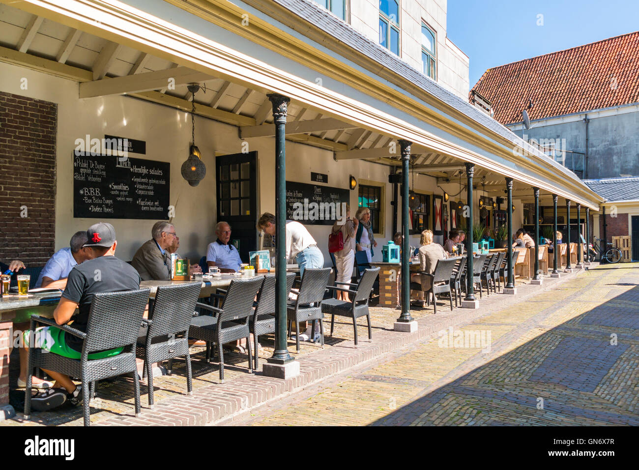 People enjoying drinks on outdoor terrace on Vismarkt, former fish market, in Alkmaar, Netherlands Stock Photo