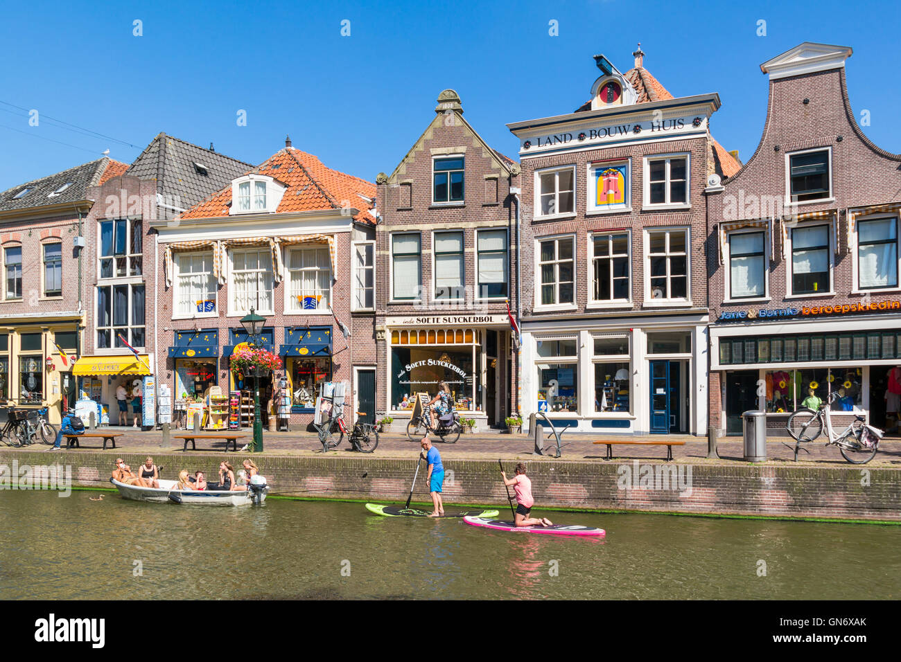 People in boat and paddle surfing on Voordam canal in Alkmaar, Netherlands Stock Photo